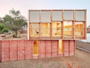 Casa sobre un zócalo de ladrillo, de Ágora Arquitectura.