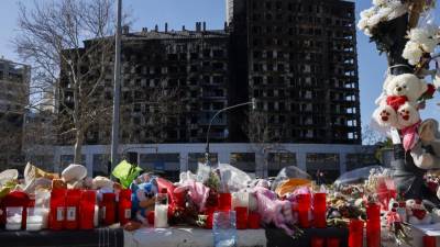 Detalle de flores, velas y peluches colocados a modo de homenaje ante el edificio incendiado en el barrio de Campanar de València en el que murieron diez personas y deja más de 400 damnificados.
