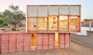 Casa sobre un zócalo de ladrillo, un trabajo de Ágora Arquitectura.