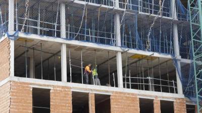 Operarios trabajando en la construcción de un bloque de viviendas en Xàtiva.