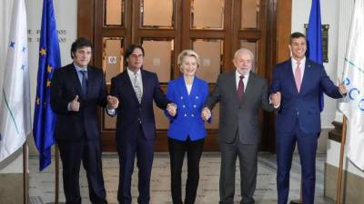 El presidente de Argentina, Javier Milei, el presidente de Uruguay, Luis Lacalle Pou, la presidenta de la Comisión Europea, Ursula von der Leyen, el presidente de Brasil, Luiz Inácio Lula da Silva, y el presidente de Paraguay, Santiago Peña, se toman de la mano mientras posan para una fotografía, en la Cumbre del Mercosur en Montevideo