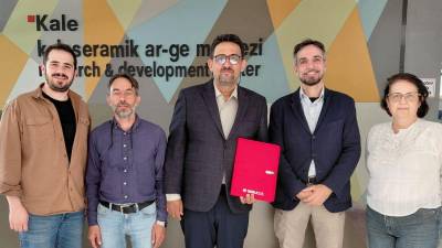 El doctor Kağan Kayaci sostiene la carpeta de congresista de Qualicer.