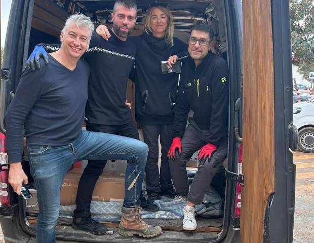 $!David junto a tres voluntarios en una furgoneta habilitada para el reparto.