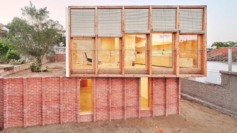 Casa sobre un zócalo de ladrillo, de Ágora Arquitectura.