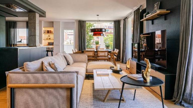 Un ático con terraza y abundante luz natural, decorado en tonos oscuros, por Coblonal